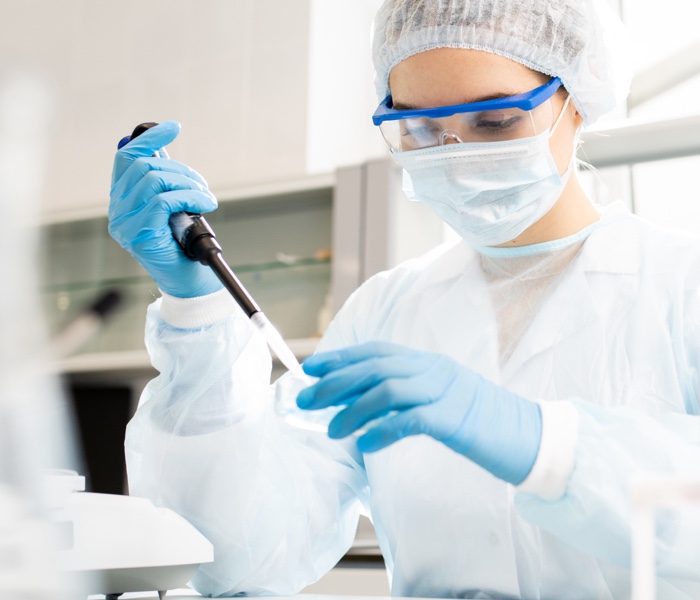 A female lab worker is performing lab research, representing the Healthcare industry