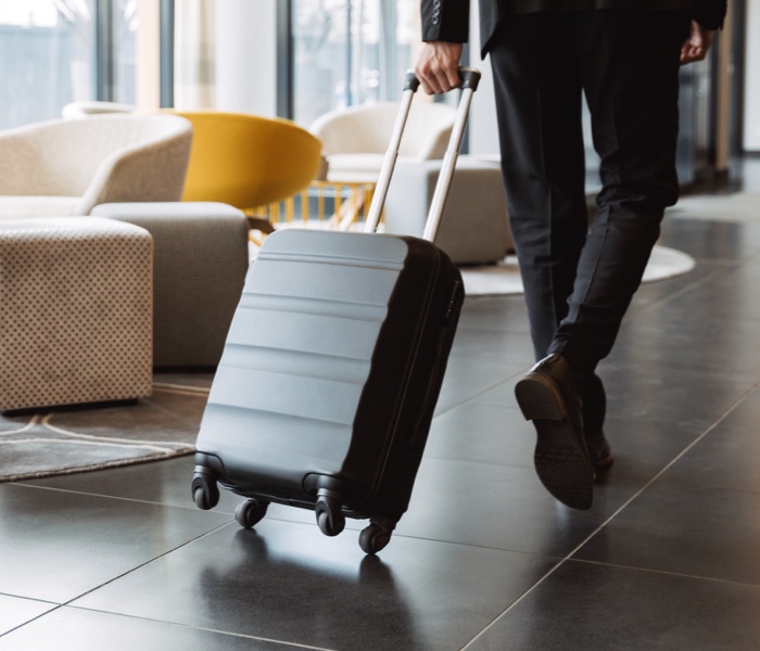 Man walking with a suitcase representing the Hospitality industry